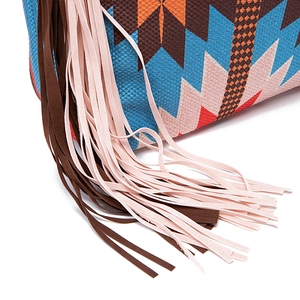 Detail shot of bohemian woven bag with colorful geometric patterns and long tassels