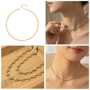 Détail du collier floral doré avec perles bleues et chaîne réglable sur bois rustique