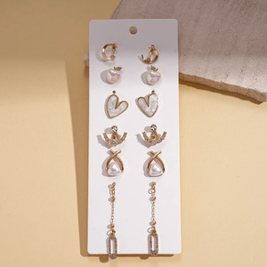 Set of 6 pairs of gold earrings with pearls and rhinestones on a white display card