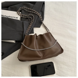 Detail of a dark brown ruched cloud bag with woven chain strap and metallic chain