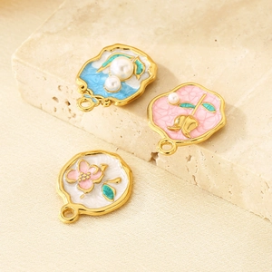 Vue détaillée de pendentifs fleurs en émail doré 18K rétro avec perles sur pierre