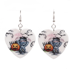 Detail view of heart-shaped Halloween earrings featuring mummy and pumpkin patterns
