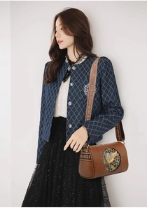 Brown cylindrical crossbody bag with vintage embossed patterns and a wide strap