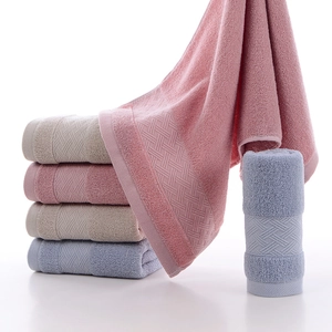 Three premium cotton towels in pink beige and blue with textured weave and soft pile surface