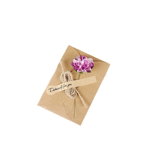 Handmade brown kraft paper greeting card with purple paper flower and jute rope bow decor