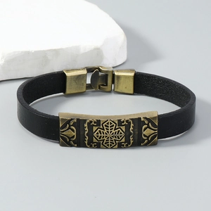 Detail of a vintage black leather bracelet featuring an antique bronze metal buckle