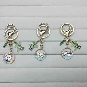 Cute panda metal keychains with enamel finish and bamboo charms on display tray