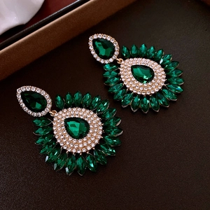 Détail de boucles d'oreilles vintage goutte d'émeraude avec placage or et strass