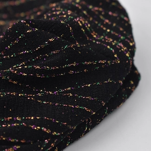 Detail of black knit hat featuring glittery green purple and gold metallic threads