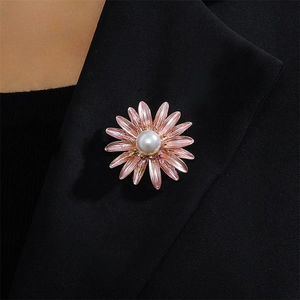 Elegant pink enamel daisy brooch with pearl center pinned on a black suit lapel