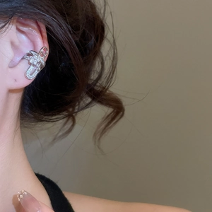 Close-up of a silver zircon ear cuff featuring a criss-cross geometric flower design