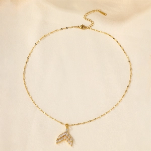 Detailed close-up of golden mermaid tail necklace with sparkling zircon on silk