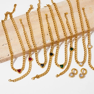 Minimalist gold heart jewelry set with colorful pendants on elegant stone tile