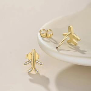 Close-up of gold airplane stud earrings with sparkling cubic zirconia and S925 hallmark