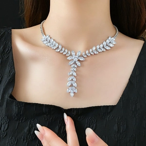 Close-up of silver zircon wheat tassel necklace on model against black background