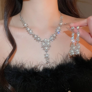 Detail of vintage silver flower necklace and earring set with pearls and rhinestones