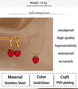Détail macro du set bijoux pomme rouge en acier inoxydable avec placage PVD doré