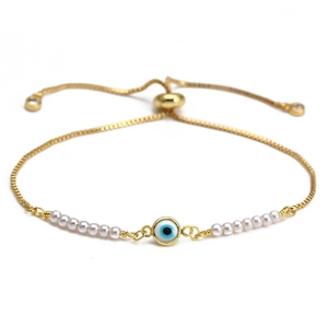 Bracciale occhio del diavolo dorato con perle bianche e catena regolabile su sfondo bianco