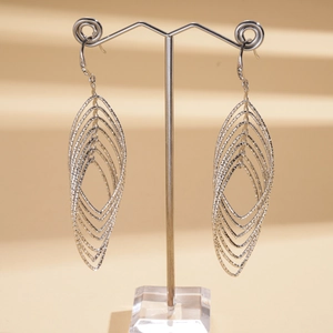 Macro detail of layered marquise-shaped silver earrings on a professional display stand