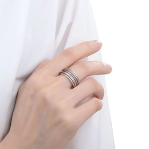 Close-up of minimalist multilayer silver ring on model finger with sleek metallic finish