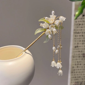 Golden lily of the valley hair stick with silk tassels in a white ceramic vase