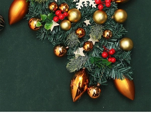 Close-up of Christmas wreath with golden balls, red berries and pine needles