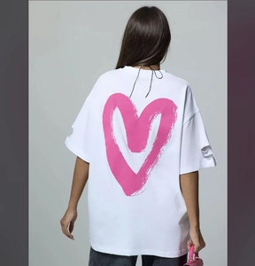 Detail of pink heart graphic on white washed tee with distressed ripped sleeve edges