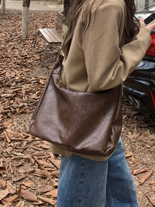 Macro shot of dark brown soft leather hobo bag with vintage slouchy texture and large capacity