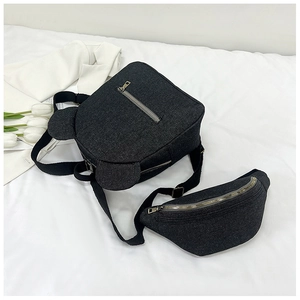 Detail of dark grey canvas backpack and moon-shaped waist bag set on a white bedding