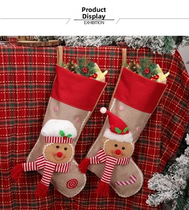 Detail of burlap Christmas stockings featuring 3D gingerbread man embroidery and pine accents