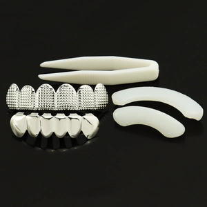 Detail view of silver hip hop grillz set with textured upper teeth and matching tweezers