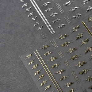 Vista macro dettagliata di adesivi 3D per unghie in metallo liquido oro e argento