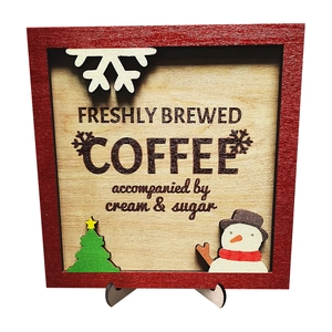 Macro view of wooden coffee sign with snowflake, Christmas tree and snowman ornaments
