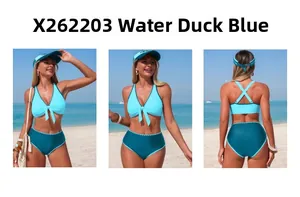 Three-way view of teal blue high waist bikini set with halter bow top on a beach
