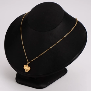 Golden heart necklace with sunburst texture and beaded edge on black display stand