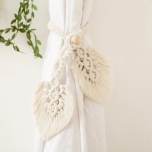 Detail of handcrafted macrame leaf curtain tiebacks with wood beads in cream cotton