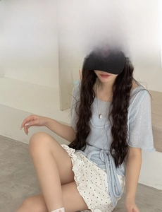 Detail of light blue knit top with waist tie and white polka dot ruffle skirt set