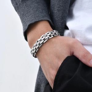 Polished silver stainless steel chain bracelet detail on male wrist for business style