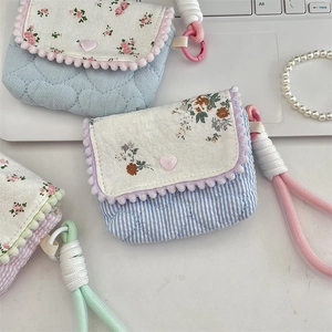 Detail of floral quilted cotton camera pouches with heart clasp and cord straps