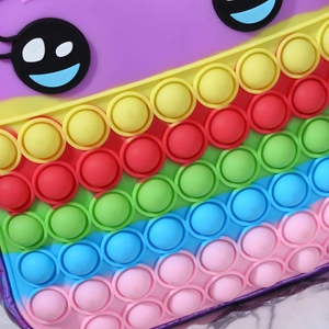 Detailed close-up of rainbow pop-it fidget backpack with silicone bubbles and cartoon eyes