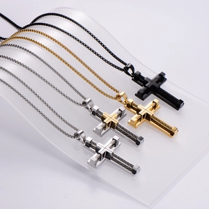 Cross pendant necklaces in gold, silver, and black stainless steel on display stand