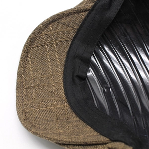 Macro detail of brown checkered fabric texture and sweatband on a newsboy cap