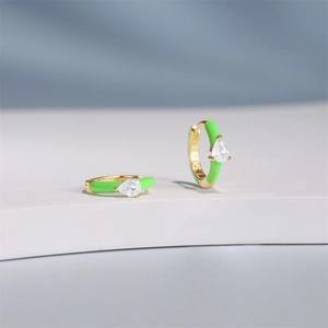 Macro detail of S925 sterling silver earrings with green enamel and pear-cut zircon