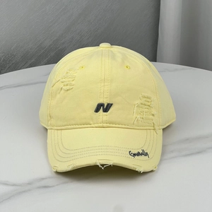 Distressed yellow baseball cap with N embroidery and vintage ripped details for women