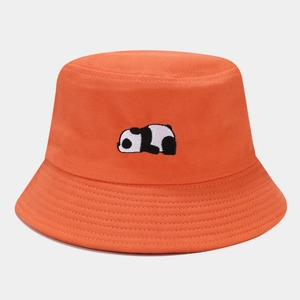 Detail view of the intricate panda embroidery on a bright orange cotton bucket hat