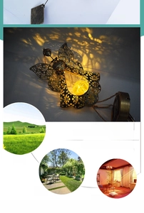 Detail of angel solar wind chime with warm yellow cracked glass ball and hollow metal patterns