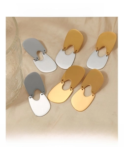 U-shaped stainless steel earrings in gold, silver, and mixed tones on beige satin