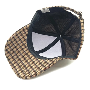 Detailed interior of plaid baseball cap showing 100% polyester fabric and adjustable strap