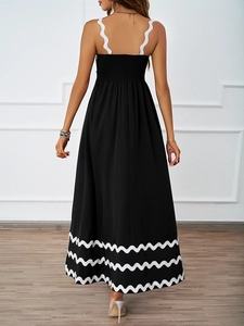 Detail of elegant black sundress featuring wavy white straps and open back design