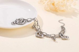 Détail du bracelet multicouche en acier inoxydable avec breloques cœur et perles argentées